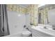 Clean bathroom with white vanity, bathtub, and patterned wallpaper at 100 Bluff View Dr # 207C, Belleair Bluffs, FL 33770