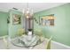 Dining area with chandelier, glass table, and view into the kitchen at 100 Bluff View Dr # 207C, Belleair Bluffs, FL 33770