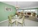 Dining room features a glass table and chairs with a view into the living room with water views at 100 Bluff View Dr # 207C, Belleair Bluffs, FL 33770