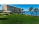 Expansive green lawn near the waterfront, featuring palm trees, walkways, and seating, adjacent to the building at 100 Bluff View Dr # 207C, Belleair Bluffs, FL 33770