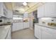 Bright kitchen featuring white cabinets, tile backsplash, and a pass-through to the dining room at 100 Bluff View Dr # 207C, Belleair Bluffs, FL 33770