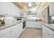 Bright white kitchen with ample cabinets, updated appliances, and tiled floor at 100 Bluff View Dr # 207C, Belleair Bluffs, FL 33770