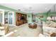 Bright living room featuring a ceiling fan, mirrored wall, and wooden entertainment center with a TV at 100 Bluff View Dr # 207C, Belleair Bluffs, FL 33770