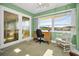 Bright office space with desk, large window, and decorative French doors at 100 Bluff View Dr # 207C, Belleair Bluffs, FL 33770