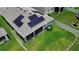 Aerial view of the backyard with solar panels, a screened lanai, and a well-maintained lawn at 10058 Shoreline View Way, Wesley Chapel, FL 33545