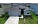 Charming single-story home featuring a well-manicured lawn, attached two-car garage, and inviting front entrance at 10058 Shoreline View Way, Wesley Chapel, FL 33545