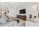 Spacious living room with sectional sofa, large TV, and ample natural light at 10058 Shoreline View Way, Wesley Chapel, FL 33545