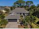 Attractive single-story home with gray roof, attached garage, and lush landscaping at 1012 Osprey Ct, Tarpon Springs, FL 34689