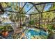Relaxing screened porch overlooking the water with plenty of plants at 1012 Osprey Ct, Tarpon Springs, FL 34689