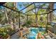 Relaxing screened porch with rocking chairs and lush tropical plants at 1012 Osprey Ct, Tarpon Springs, FL 34689