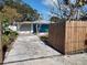 Front view of a blue house with a wooden fence and a long driveway at 1644 24Th N Ave, St Petersburg, FL 33713