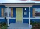 Light-yellow front door with blue house exterior and wooden shutters at 1644 24Th N Ave, St Petersburg, FL 33713