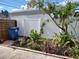 Side yard with plants and a blue recycling bin at 1644 24Th N Ave, St Petersburg, FL 33713