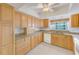 Kitchen features light wood cabinets, granite countertops and a ceiling fan at 2579 Forest Run Ct, Clearwater, FL 33761