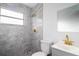 Bathroom with gray marble-look tile, a shower, and gold fixtures at 3014 E Osborne Ave, Tampa, FL 33610