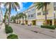 Row of townhouses with lush landscaping and a palm tree-lined street at 3192 Nautical S Pl, St Petersburg, FL 33712