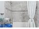 Modern bathroom with gray tile, shower, and white bathtub at 3192 Nautical S Pl, St Petersburg, FL 33712