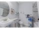 Bright bathroom features a single sink, white wicker cabinet and tiled shower and bath at 3192 Nautical S Pl, St Petersburg, FL 33712