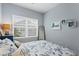 Cozy bedroom with blue coastal themed décor, window with blinds, and full length mirror at 3192 Nautical S Pl, St Petersburg, FL 33712
