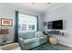 Sitting area with teal sofa, TV, and calming decor at 3192 Nautical S Pl, St Petersburg, FL 33712