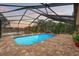 Inviting pool area with screened enclosure, pavers, and tranquil water views at 478 Fieldstone Ln, Spring Hill, FL 34606