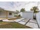 Enclosed backyard with patio, storage shed, stepping stones, and lush landscaping at 500 Randolph Rd, Venice, FL 34293