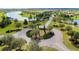 Scenic aerial view of a tranquil community with lush landscaping, a circular driveway, and surrounding waterways at 5111 Lake Toscana Dr, Wimauma, FL 33598