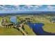 Aerial view of a community with houses, a lake, and a bridge at 5111 Lake Toscana Dr, Wimauma, FL 33598