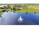 Water fountain sprays in a neighborhood lake next to residential homes and a bridge at 5111 Lake Toscana Dr, Wimauma, FL 33598