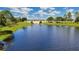 Scenic view of a community lake with a decorative bridge in the background at 5111 Lake Toscana Dr, Wimauma, FL 33598