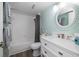 White vanity, large mirror, shower/tub combo, and gray accents at 9815 Harrell Ave # 302, Treasure Island, FL 33706