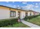 Charming front exterior view of a condo unit, highlighting the walkway, landscaping, and the building's facade under a bright blue sky at 11511 113Th St # 27C, Largo, FL 33778
