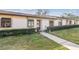 Front exterior of a single-story condo on a sunny day, showcasing a well-maintained lawn, shrubs, and a welcoming walkway at 11511 113Th St # 27C, Largo, FL 33778