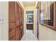 Hallway with tiled floors and louvered closet doors leading towards a bathroom at 11511 113Th St # 27C, Largo, FL 33778