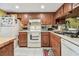 Kitchen featuring wood cabinets, white appliances, and tile flooring at 11511 113Th St # 27C, Largo, FL 33778