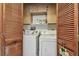 Laundry room with a stacked washer and dryer unit behind folding doors at 11511 113Th St # 27C, Largo, FL 33778