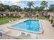 Aerial view of a community pool surrounded by a fence, lounge chairs, and landscaping at 11511 113Th St # 27C, Largo, FL 33778