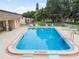 Community pool with lounge chairs, surrounded by a paved deck and fence at 11511 113Th St # 27C, Largo, FL 33778