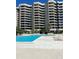 Resort-style pool and sundeck area with a large building in the background at 1211 Gulf Of Mexico Dr # 910, Longboat Key, FL 34228