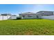 Backyard featuring a spacious lawn with a white fence and view of the home's exterior at 13388 Great Plains Dr, Riverview, FL 33579