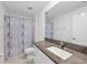 Bathroom with granite vanity top, undermount sink, and shower featuring a blue patterned shower curtain at 13388 Great Plains Dr, Riverview, FL 33579