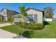 Lovely home featuring a well-manicured front yard with decorative bushes and a palm tree at 13388 Great Plains Dr, Riverview, FL 33579