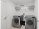 Bright laundry room featuring a washer, a dryer, shelving, and tile flooring at 13388 Great Plains Dr, Riverview, FL 33579