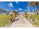 Inviting community entrance with a paved pathway, lush landscaping, and gated access at 18320 Gulf Blvd # 303, Redington Shores, FL 33708