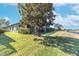 Landscaped backyard with a large magnolia tree and water view at 225 Mystic Falls Dr, Apollo Beach, FL 33572