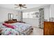 Cozy bedroom featuring a ceiling fan, large window, and classic wood furniture at 2465 Northside Dr # 1808, Clearwater, FL 33761