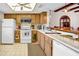 Kitchen features wood cabinets, white appliances, and tile flooring at 2465 Northside Dr # 1808, Clearwater, FL 33761