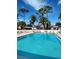 Sparkling blue community pool surrounded by palm trees and lounge chairs at 2465 Northside Dr # 1808, Clearwater, FL 33761