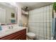 Bathroom with wood vanity and striped shower curtain at 2713 Apia Pl, Holiday, FL 34691