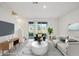 Virtually staged living room with gray couch and patio doors at 32925 Pez Landing Ln, Wesley Chapel, FL 33543